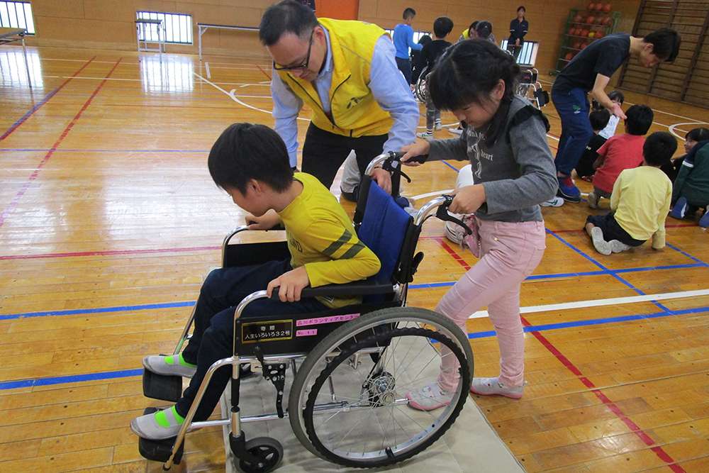 車いすを押す女子児童