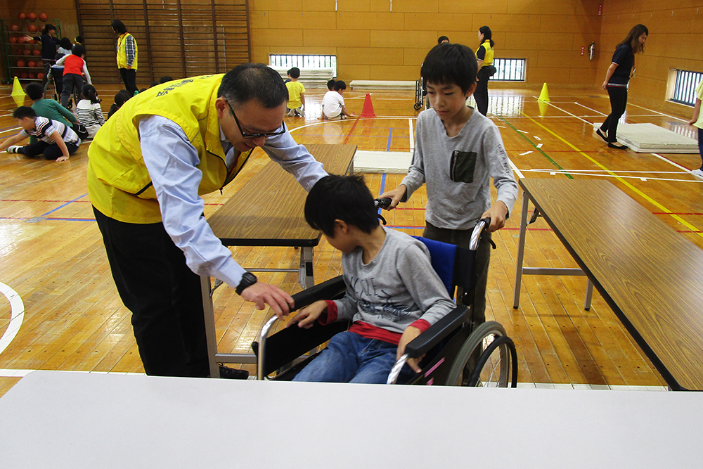 車いすを押す男子児童