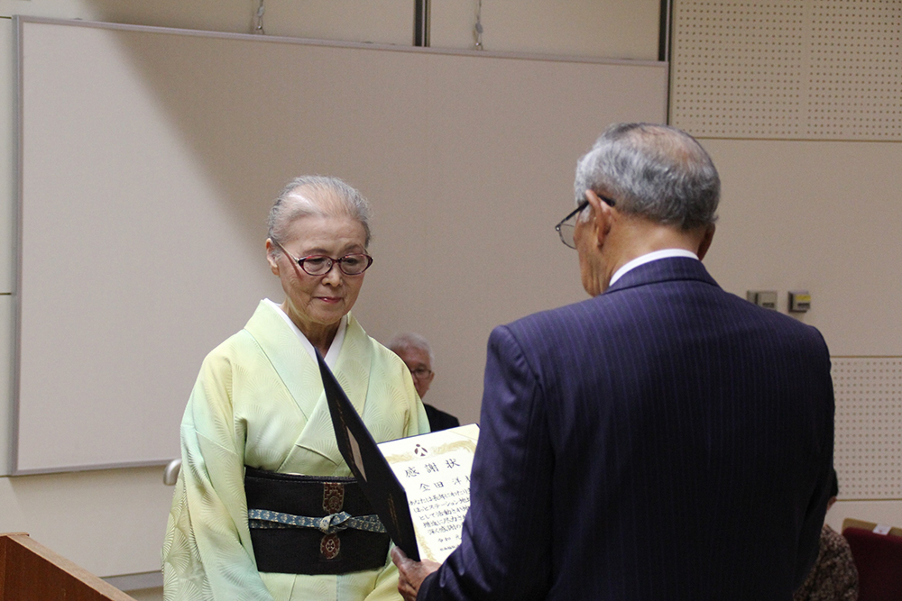 感謝状を受け取る和服の女性