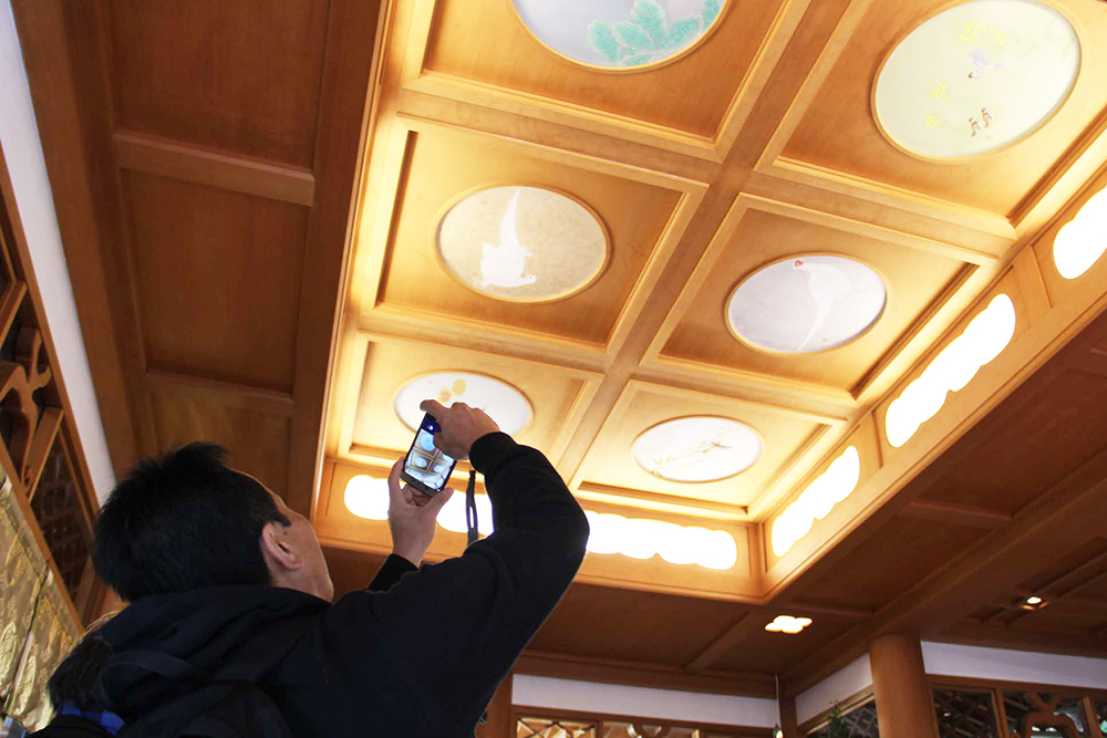 雉子神社の天井画の写真を撮る参加者