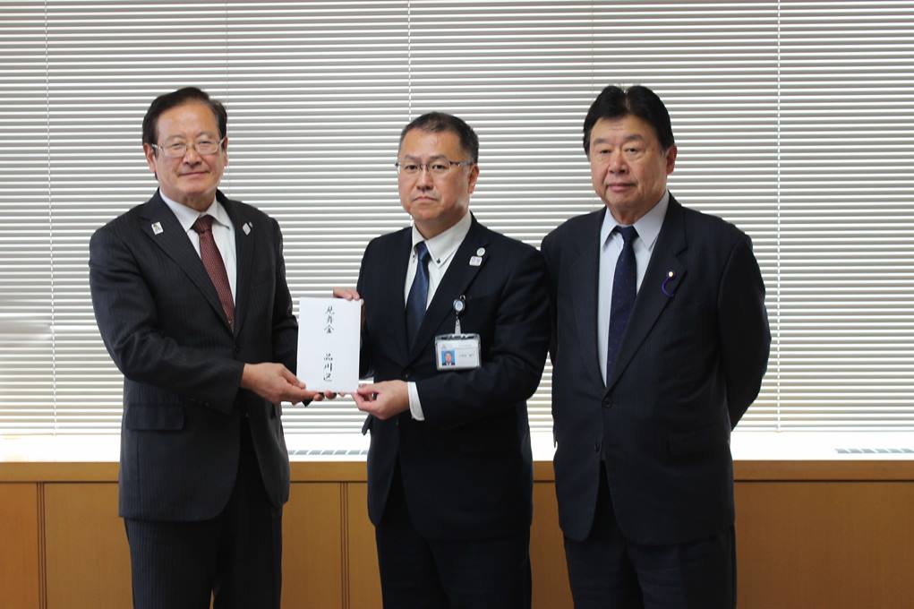 見舞金を手渡す様子（左側 湯川裕司 町長　中央　久保田善行　地域振興部長　右側　府川輝夫　議長））