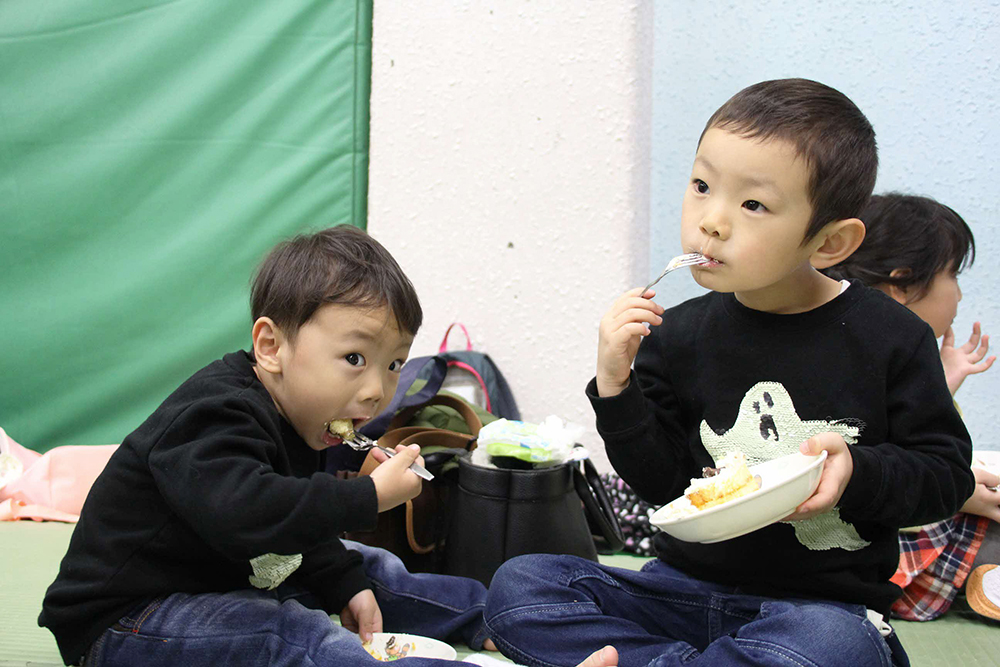 大口を開けてケーキをほおばる男の子たち