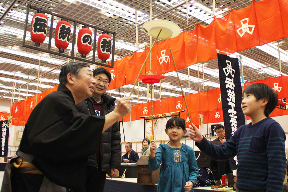 大道芸に子どもが挑戦する様子