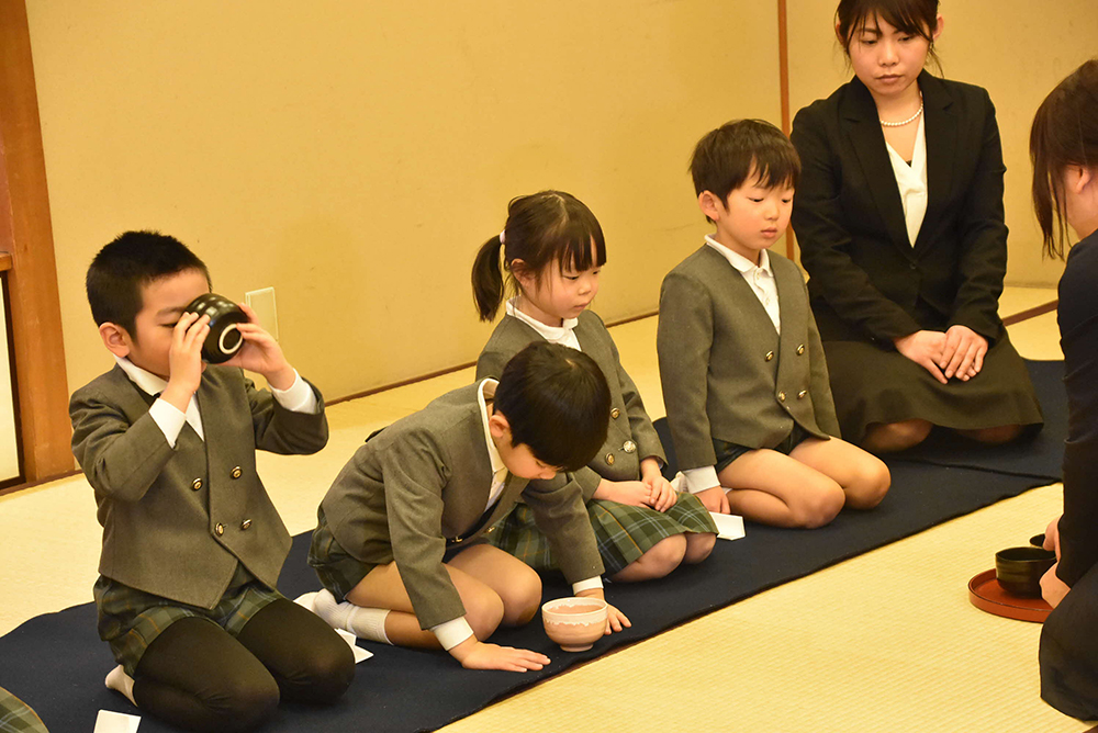 お茶を飲む子とお辞儀をする子