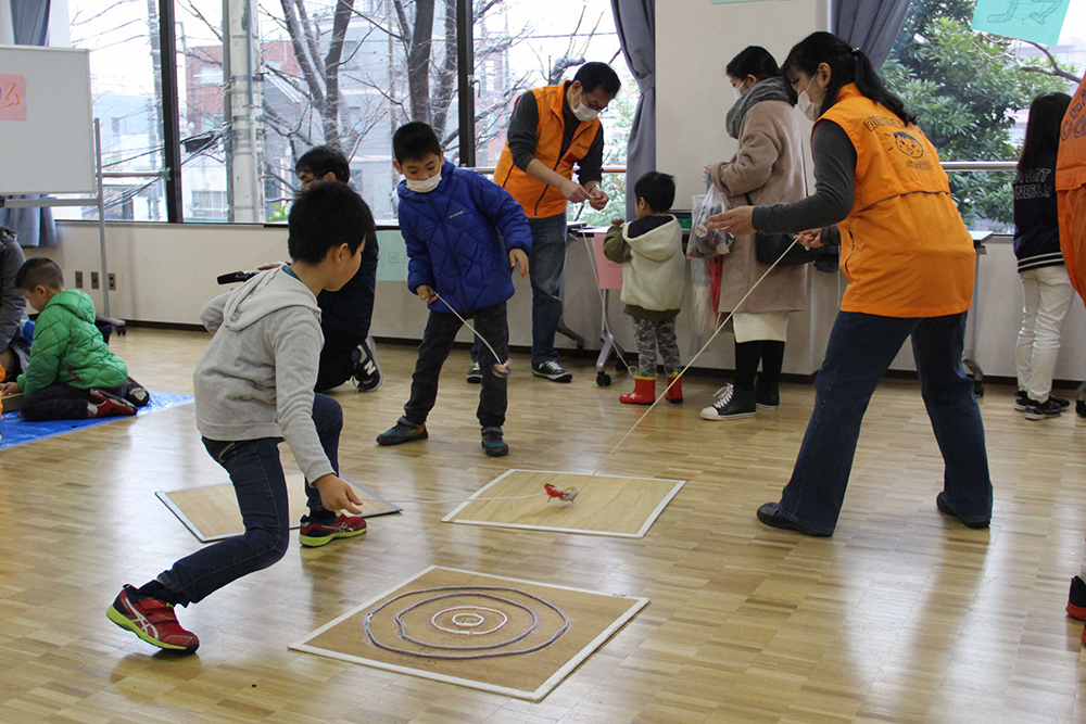 上手にコマを回す男の子たち