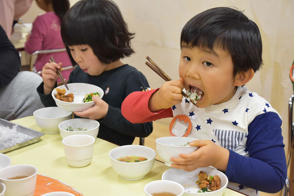 アルファ化米を使ったわかめご飯を食べる園児