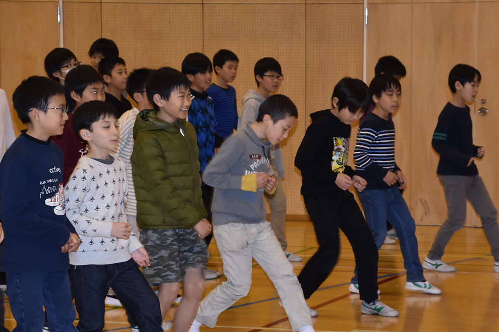 サルサダンスのステップを練習する児童たち