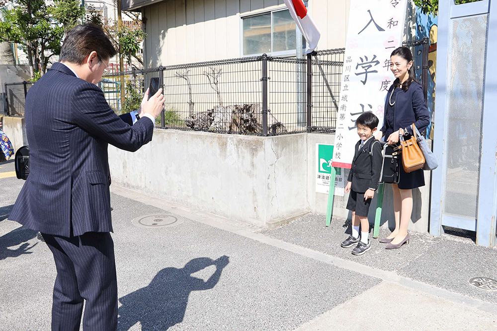 校門で記念撮影する親子2