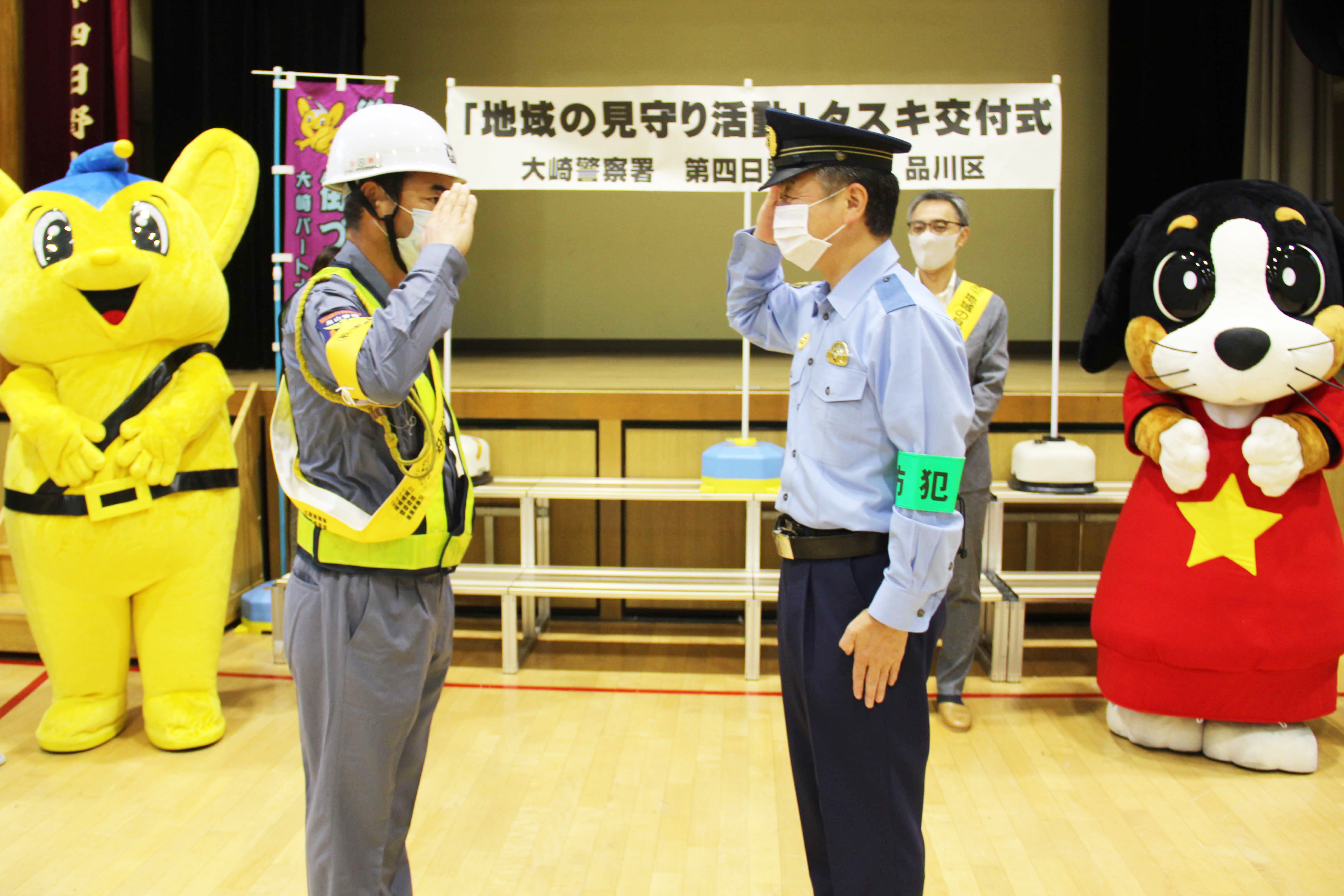 大崎署長とガードマンが敬礼する様子