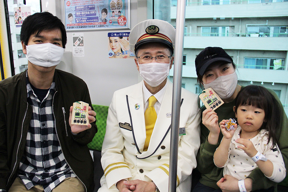 夢さんばし号で大崎駅長と記念写真を撮る家族