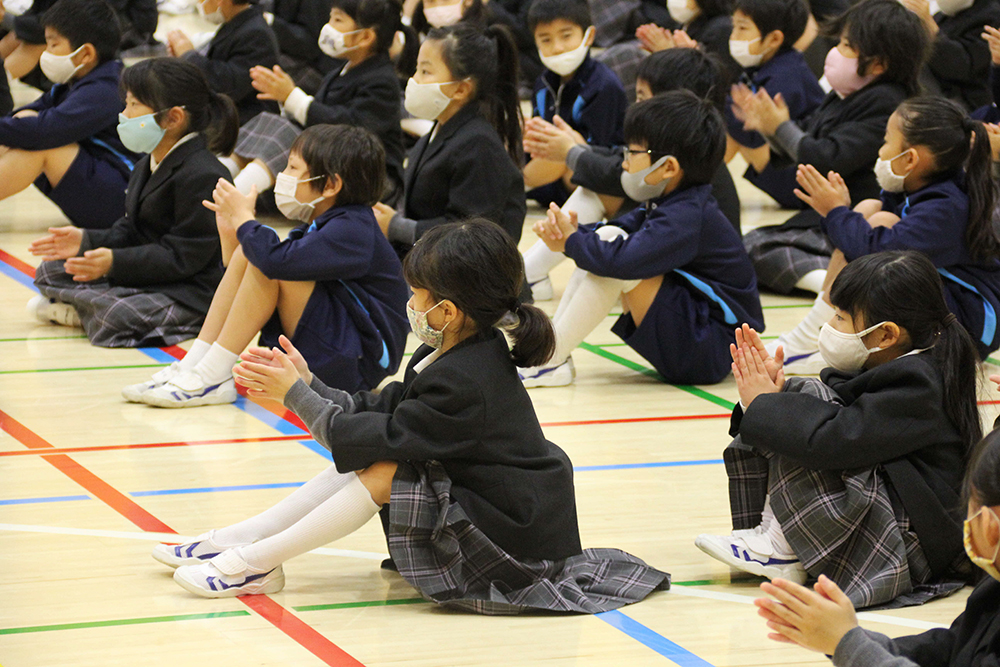 手拍子をしながら聞き入る子どもたち(1~4年生)