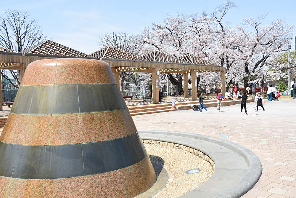 水の流れるモニュメントと桜の木