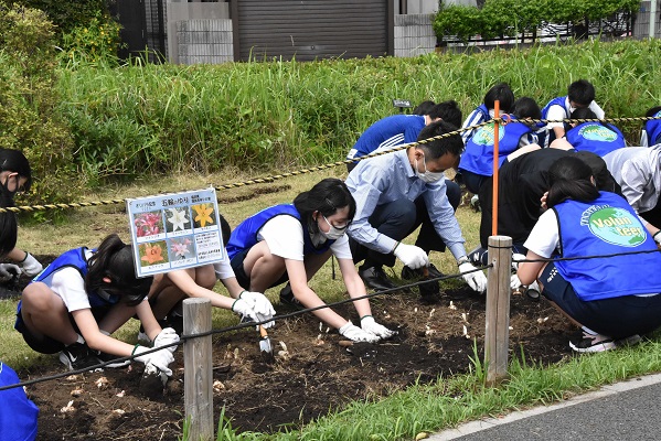 球根を植える子どもたちと校長