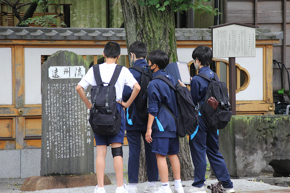 天妙国寺の石碑を見る生徒たち