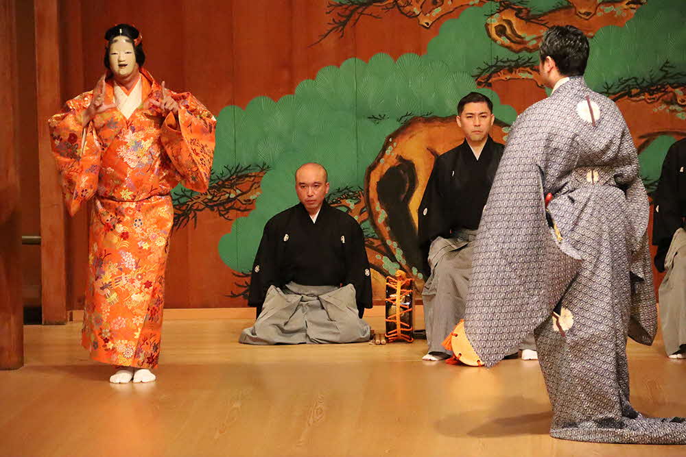 能の舞台 お面をかぶった人が手話を交えて演技
