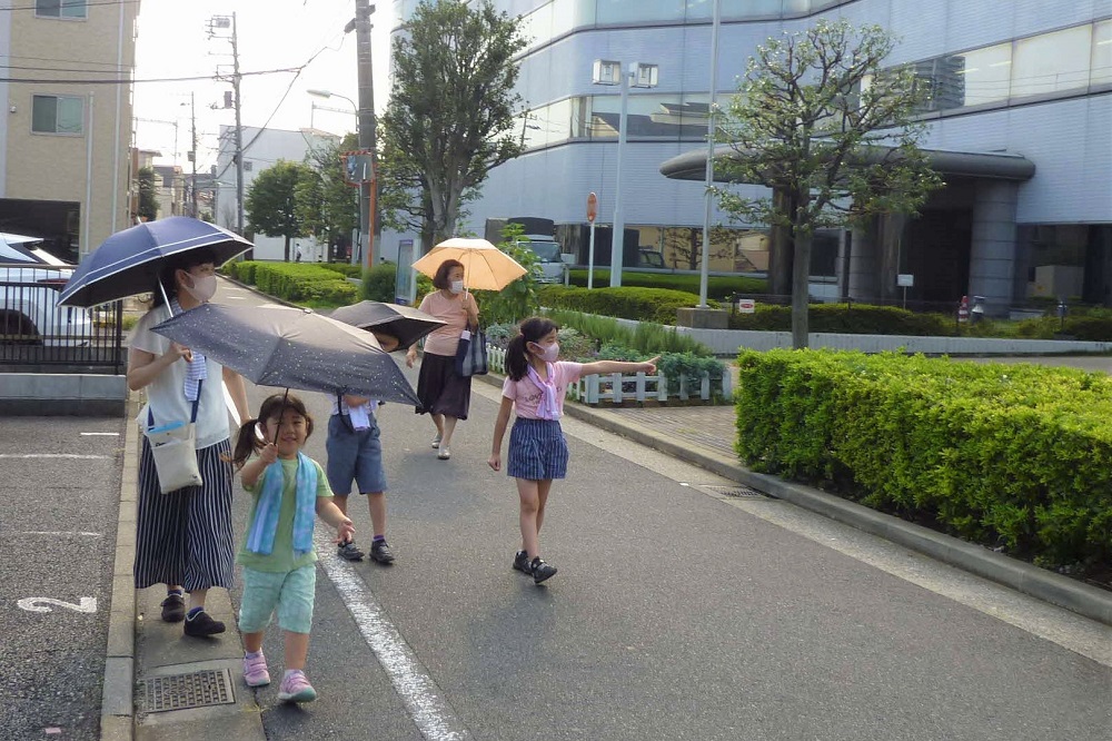 歩きながら掲示板を探す親子とおばあちゃん