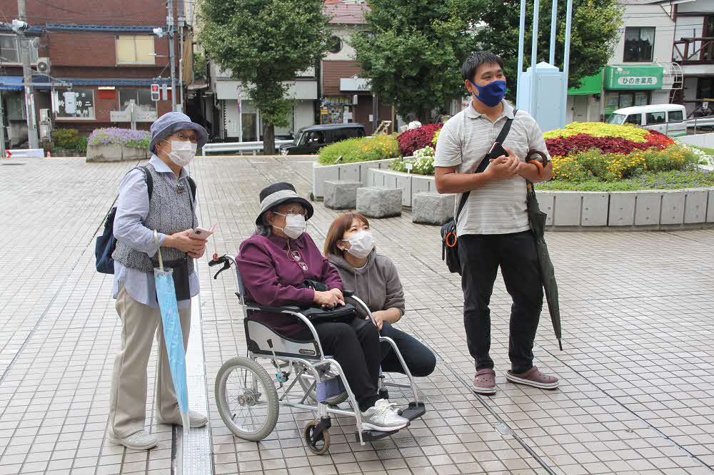 掲揚されている様子を見る岩田さんと関係者