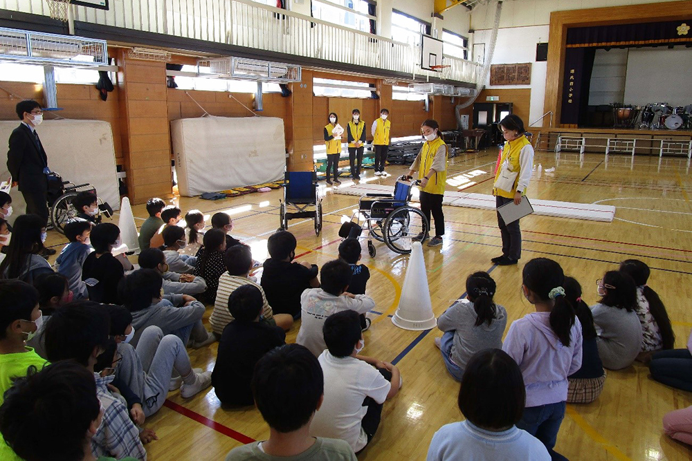 車いすの押し方の説明を受ける子どもたち