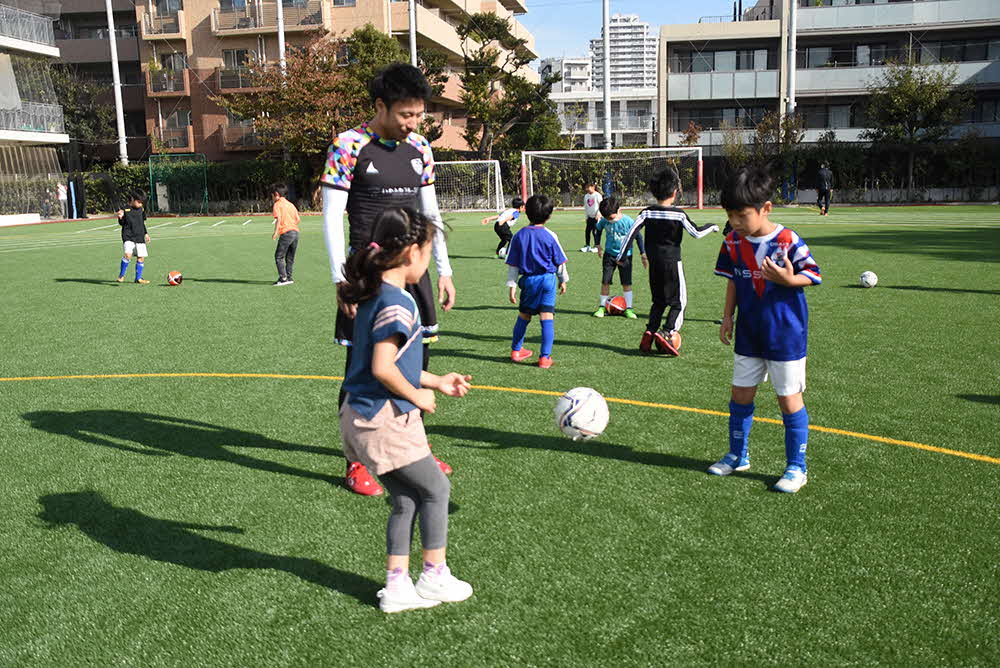 パスを教える白方秀和選手と子どもたち