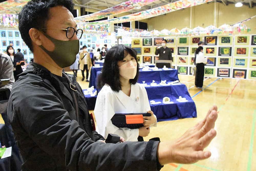 子ども学芸員と作品を見学する保護者