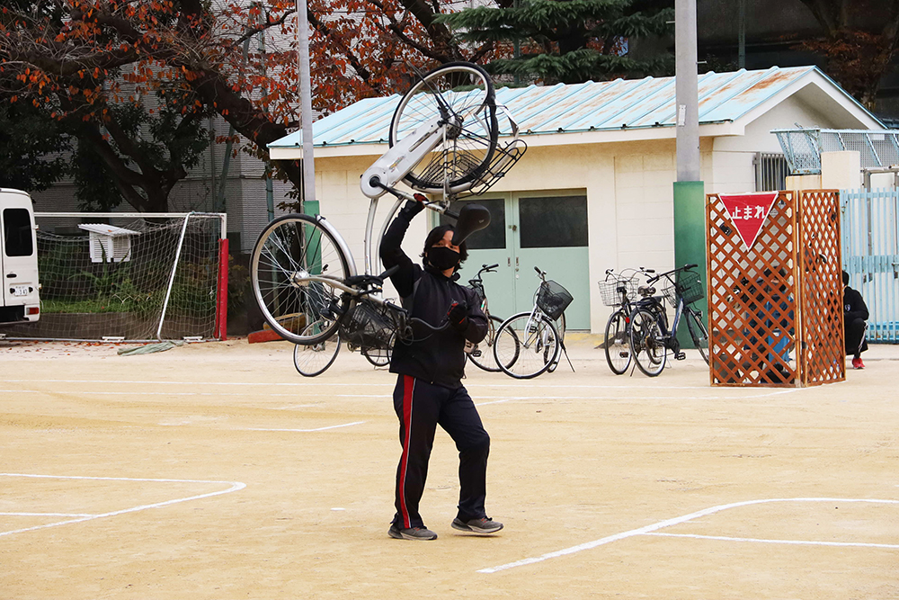 車と衝突しタイヤがひしゃげた自転車を見せる