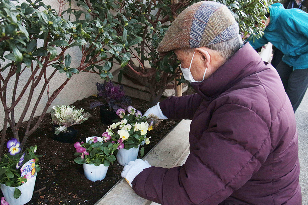 花を植える柿下秋男さん