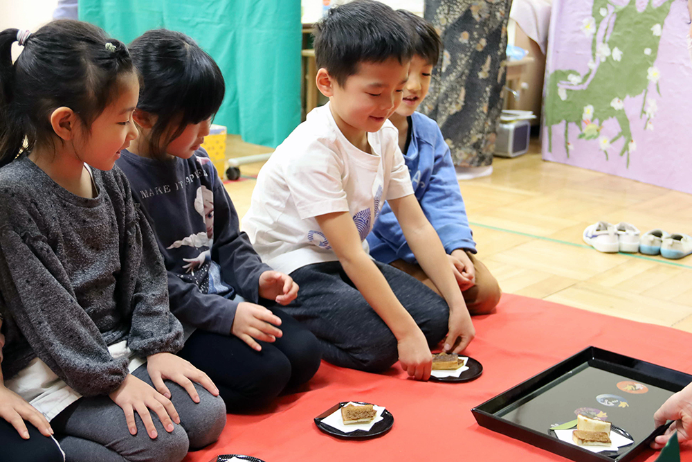 茶請けを嬉しそうに取る子ども