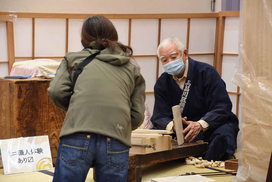 職人に質問する女性