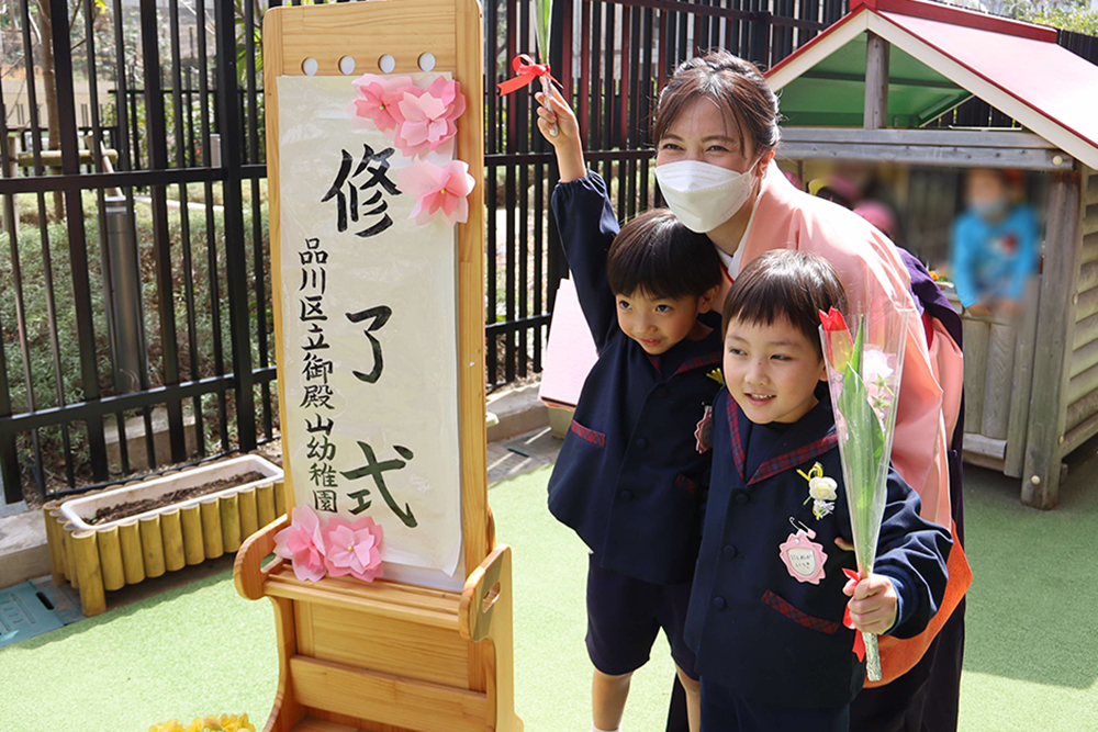 担任の先生と記念撮影をする男の子２人