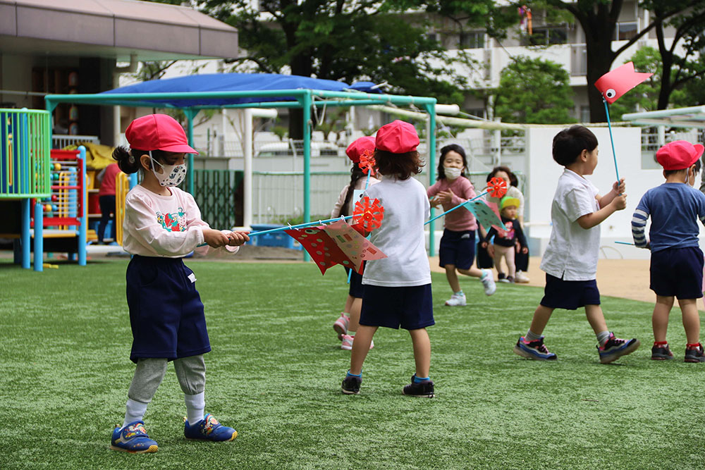 園庭で駆け回るれんげぐみの園児