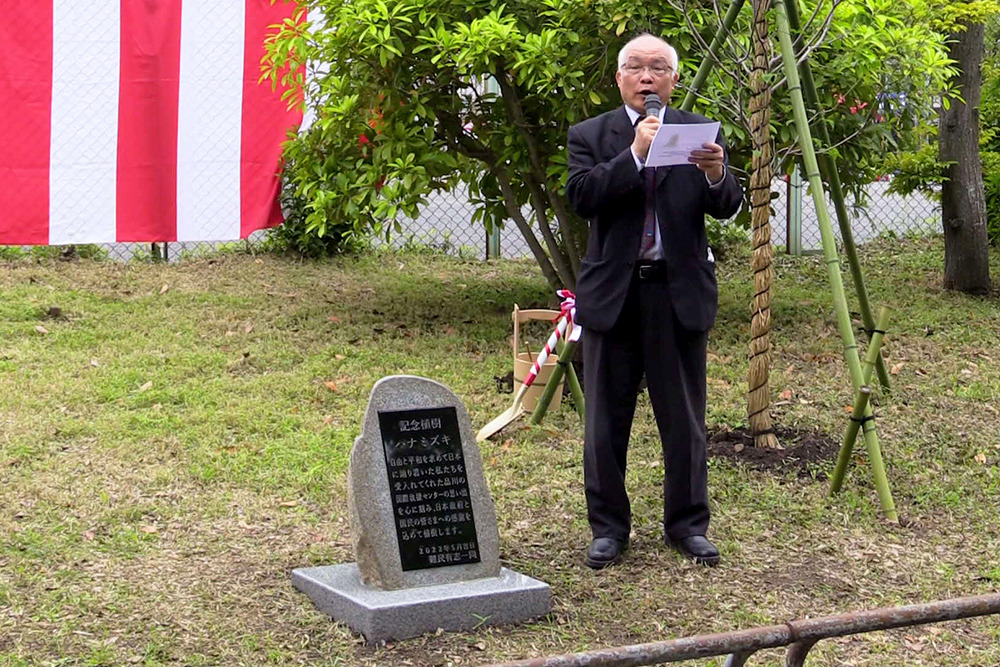 在日ベトナムカトリック共同体所属の藤田さんが石碑のメッセージを読み上げ