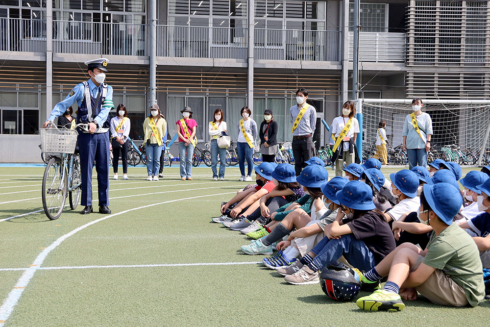 子どもたちに自転車の乗り方を説明する警察官