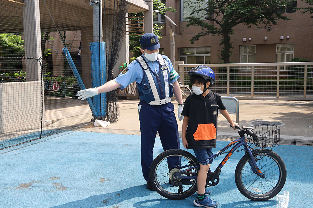 後方確認の大切さを伝える警察官