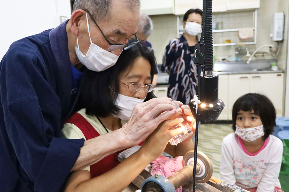 体験する参加者と見守る子ども