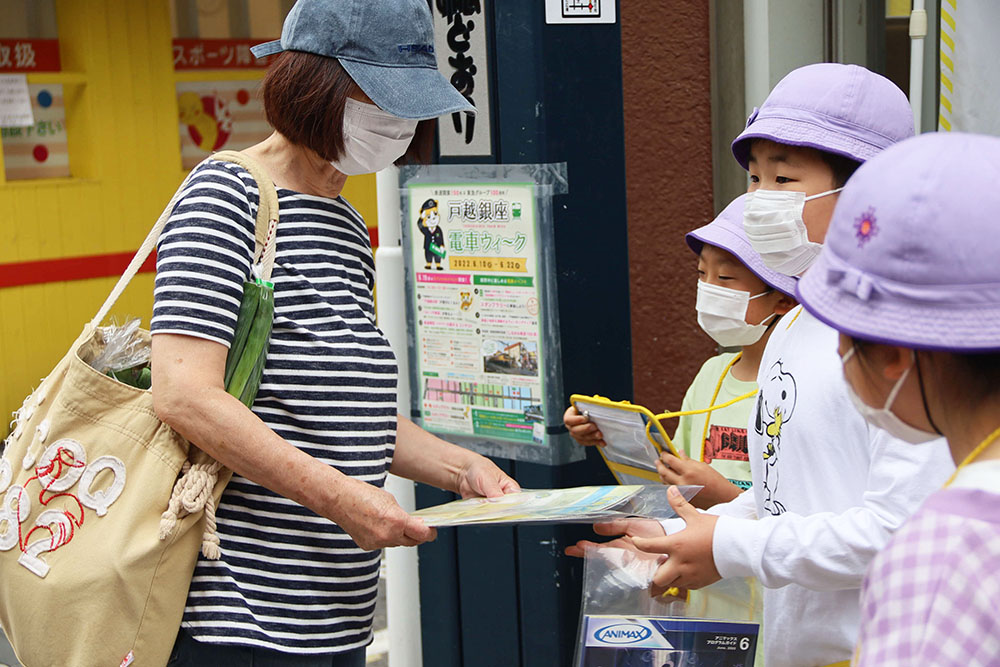 しなココの案内を通行人に渡す子どもたち