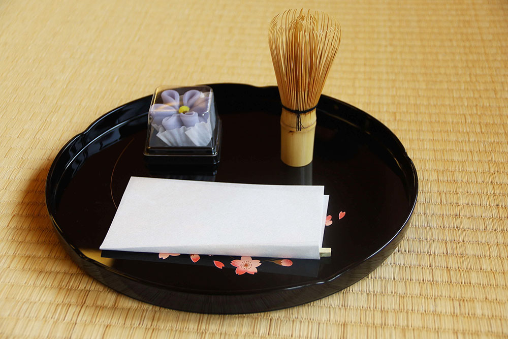 お盆と和菓子と茶筅の写真