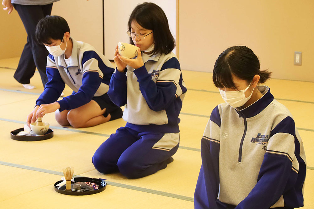 お茶を点て、飲む生徒の写真