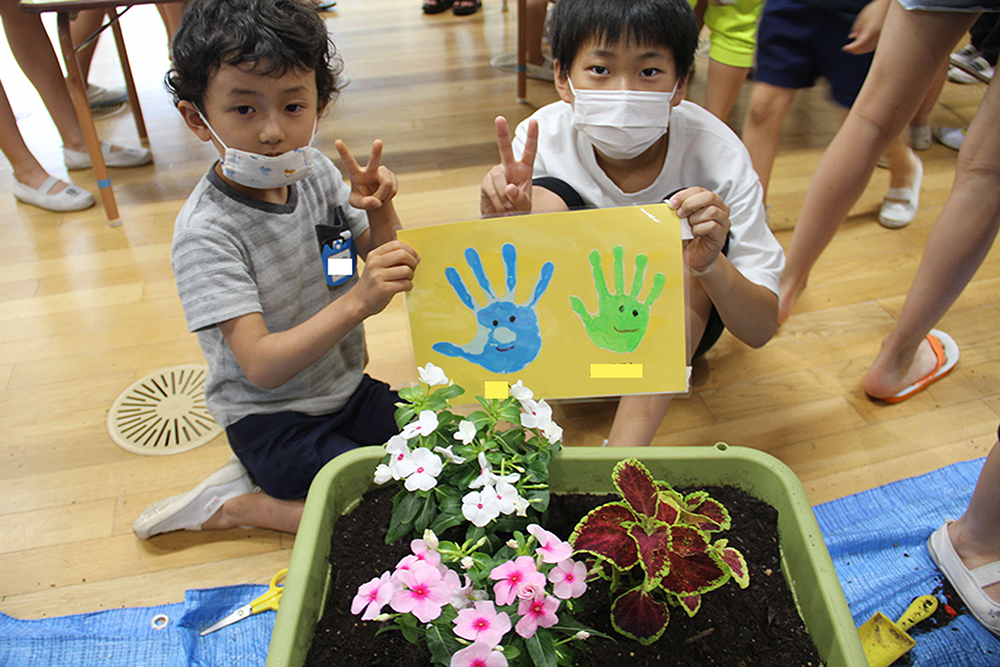 手形とお花を一緒に作って記念ポーズ