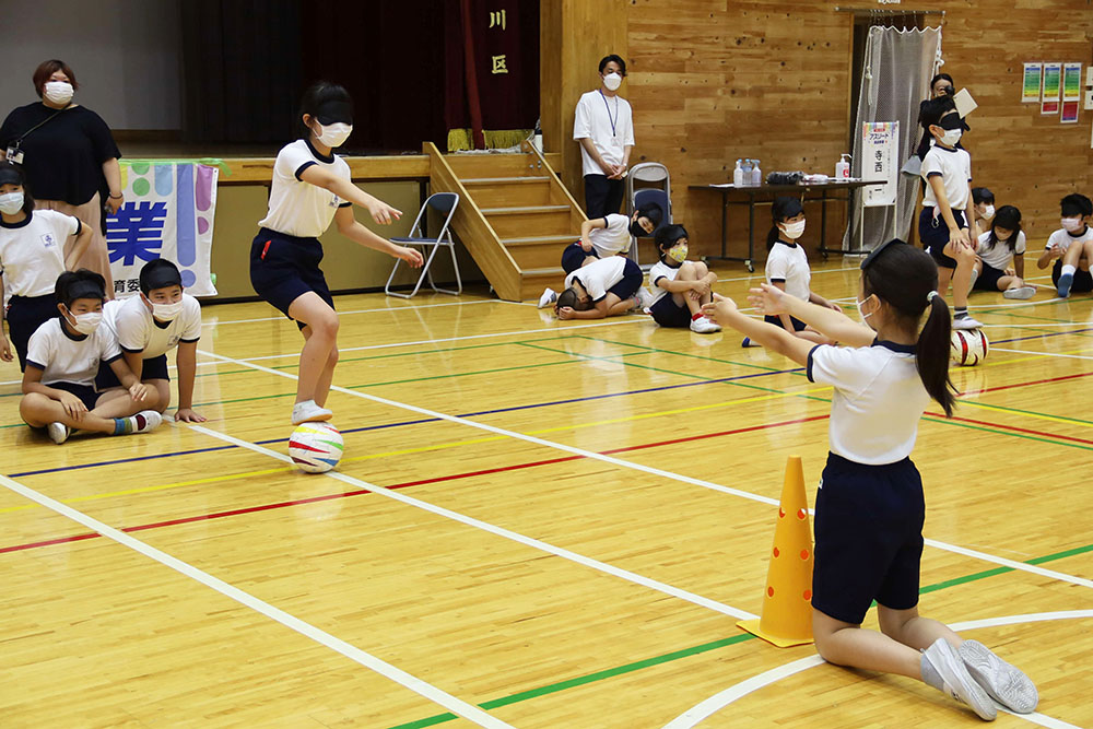 アイマスクを付けてボールを蹴る子ども