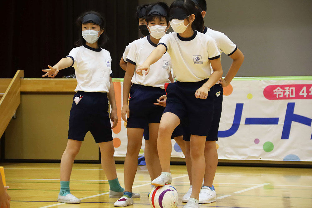 アイマスクを付けてゴールを指さす子ども