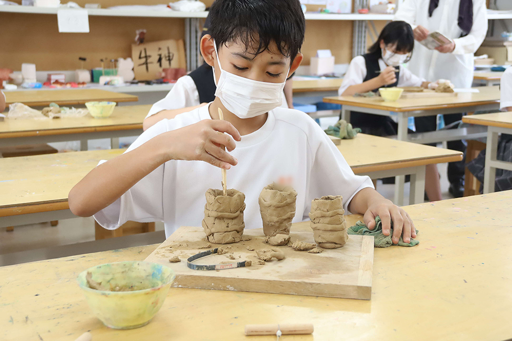 色々な形の陶器を作る児童