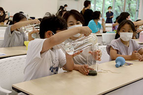 ガラスボトルに水を注ぐ参加者