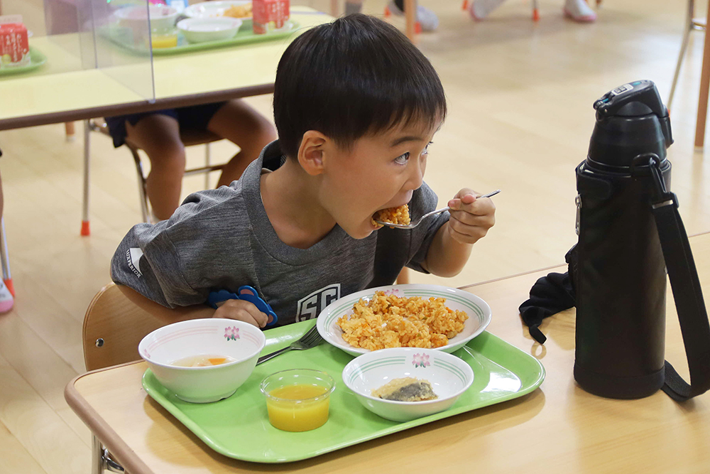 チキンライスをほおばる子ども