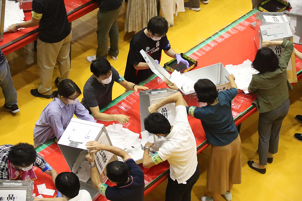 投票箱から票を取り出す