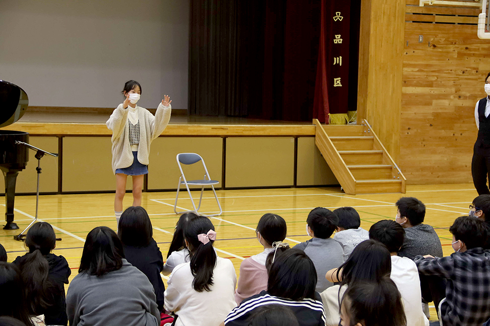 両手を使って指揮をする女ん子