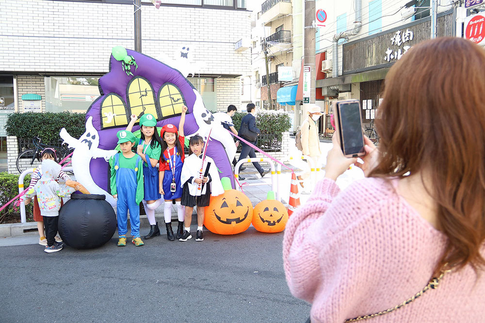 仮装した子どもたちと写真を撮る保護者