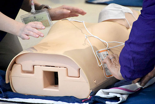 AEDの操作を教わる参加者