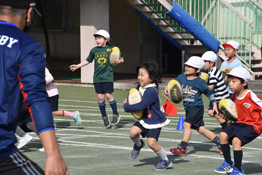 ボールを奪われないように走る子どもたち