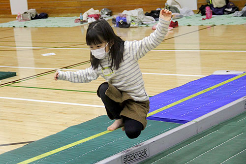 練習用のスラックラインの上でポーズをとる参加者