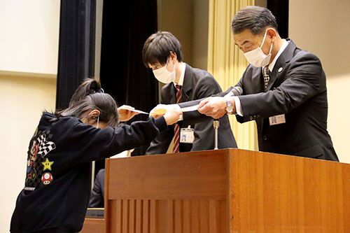 賞状をお辞儀しながら受け取る子供